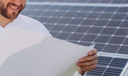 Young architect standing by solar panels